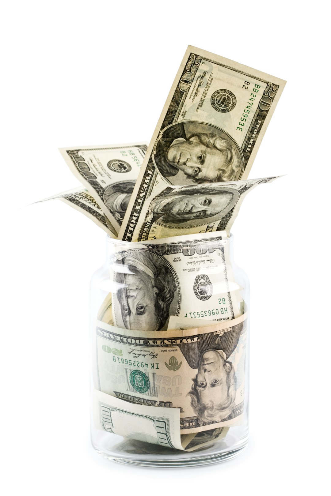 a-glass-jar-filled-with-money-sitting-on-top-of-a-table-a-nzwylksua