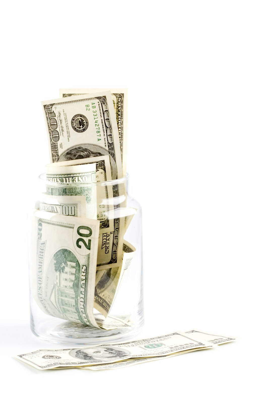 a-glass-jar-filled-with-money-sitting-on-top-of-a-table-ee2tloliooq